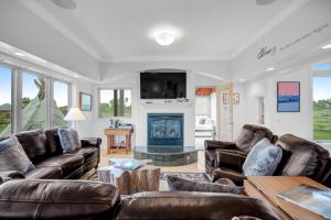 a living room with leather furniture and a fireplace at Fun w/ Family! Mtn-View Gem w/ Deck in Driggs in Driggs