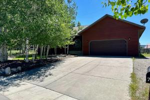 a red house with a garage and some trees at Hike, Golf & Explore: Driggs Home w/ Patio & Grill in Driggs