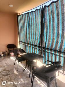 a room with two tables and chairs in front of a large window at Building 211, Gulf 2, Apartment 403 in ‘Ezbet `Abd el-Ḥamîd