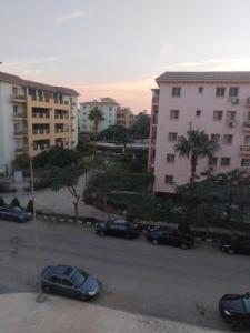 a parking lot with cars parked in front of buildings at Building 211, Gulf 2, Apartment 403 in ‘Ezbet `Abd el-Ḥamîd