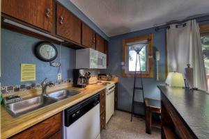 a kitchen with a sink and a clock on the wall at Slope-Side Getaway Deck Pool Table Views in Boise
