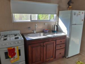 a kitchen with a sink and a white refrigerator at Depto in Navarro