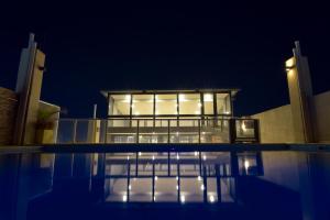 a building with a pool in front of it at night at Apart Hotel Veladero in San Juan