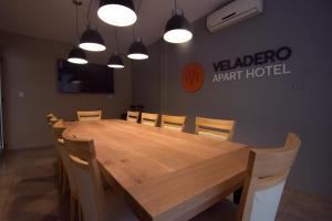 a wooden table in a room with chairs and lights at Apart Hotel Veladero in San Juan +65 photos