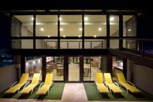 a group of yellow chairs in a building at Apart Hotel Veladero in San Juan