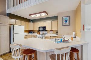 a kitchen with a large island with bar stools at McCall Mountain Condo Pool Sauna Deck in McCall +30 photos