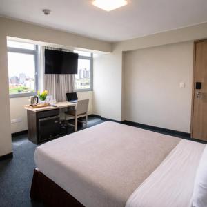 a hotel room with a bed and a desk at Palmetto Hotel Business San Miguel in Lima +26 photos