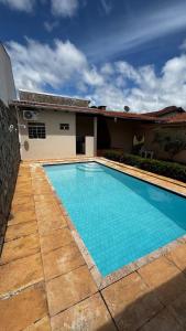 a swimming pool in front of a house at Casa com piscina 20 Leitos in Cuiabá