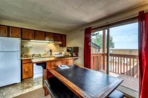 a kitchen with a refrigerator and a table and a balcony at Mountain Retreat Slope Access 2 Decks in Boise