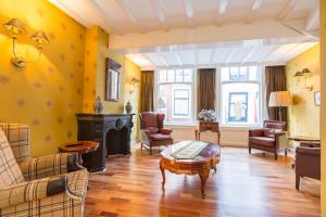 een woonkamer met gele muren en een tafel en stoelen bij The Heritage - R.Q.C. in Den Haag