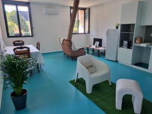 a living room with blue floors and chairs and a table at L'éveil à la nature in Limoges