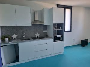 a kitchen with white cabinets and a blue floor at L'éveil à la nature in Limoges +15 photos