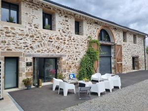 a building with white chairs and tables in front of it at L'éveil à la nature in Limoges