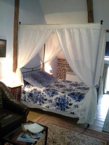 ein Schlafzimmer mit einem Himmelbett in der Unterkunft Au Mesnil Le Bas Bray in Bures-en-Bray