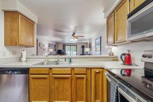 a kitchen with wooden cabinets and a sink at Golf Course Retreat - Pool Access Lake Views in McCall