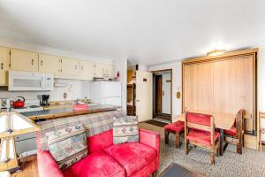 a living room with a red couch and a table at Mountain Condo Ski Access & Sunset Deck in Boise
