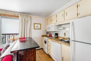 a kitchen with a sink and a refrigerator at Mountain Condo Ski Access & Sunset Deck in Boise
