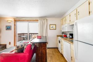a kitchen with a red couch and a refrigerator at Mountain Condo Ski Access & Sunset Deck in Boise