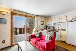 a living room with a red couch in a kitchen at Mountain Condo Ski Access & Sunset Deck in Boise
