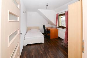 チェシンにあるSweet Family Homeのベッドとデスクが備わる小さな客室です。
