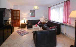 un soggiorno con mobili in pelle nera e tende rosa di Sweet Family Home a Cieszyn