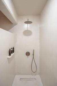 a white bathroom with a shower with a hose at Chic Elysium in Naxos Chora +25 photos