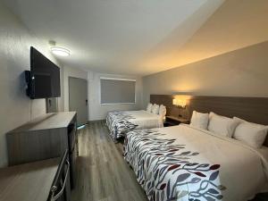 a hotel room with two beds and a flat screen tv at Red Roof Inn Reno in Reno