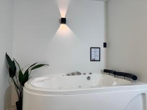 eine Badewanne in einem Badezimmer mit einer darüber angebrachten Lampe in der Unterkunft Hotel Bombay in Baños