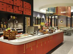 a restaurant with a counter with food on it at ibis Styles Jakarta Tanah Abang in Jakarta