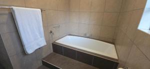 a bathroom with a tub and a white towel at Seek First B&B in Pretoria +10 photos