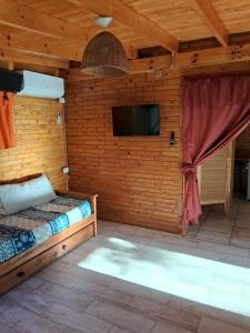 a bedroom with a bed and a flat screen tv at El Druida 3 in Villa General Belgrano