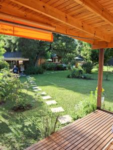 a patio with a wooden deck and a yard at El Druida 3 in Villa General Belgrano