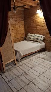 a bed in a room with a wooden wall at El Druida 3 in Villa General Belgrano