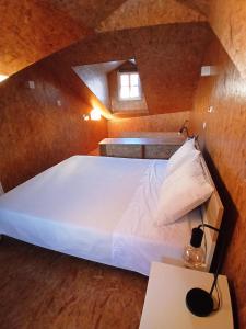 a bedroom with a large white bed in a attic at Green View Studios Coimbra in Coimbra