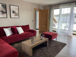 ein Wohnzimmer mit einem roten Sofa und einem Tisch in der Unterkunft Ferienwohnung Eich in Kelberg