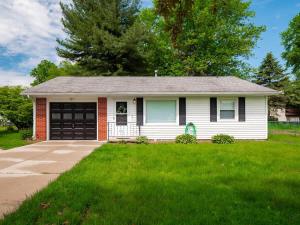 a white house with a garage and a driveway at Beautiful Ranch with Outdoor Patio and Room for 6 in Munroe Falls