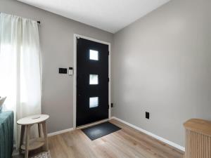 a black door in a white room with a stool at Beautiful Ranch with Outdoor Patio and Room for 6 in Munroe Falls +25 photos