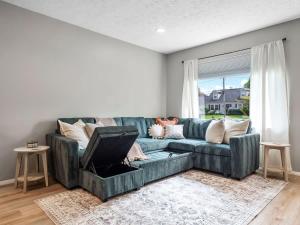 a green couch in a living room with a window at Beautiful Ranch with Outdoor Patio and Room for 6 in Munroe Falls