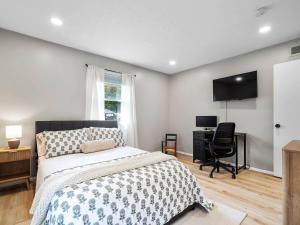a bedroom with a bed and a desk and a television at Beautiful Ranch with Outdoor Patio and Room for 6 in Munroe Falls