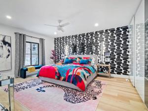 a bedroom with a colorful bed and a stone wall at PoolTable - Hot Tub - FirePit - Games - Bunk Slide - Wet Bar in Akron