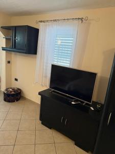 a living room with a flat screen tv on a dresser at GV - Holiday home with MagnaPool in Makarska