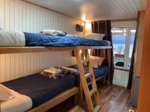 a room with two bunk beds and a balcony at Refugio Jemmy Button in Puerto Williams