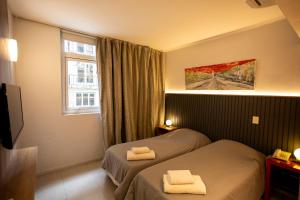 a hotel room with two beds and a window at America Del Sur Hostel Buenos Aires in Buenos Aires