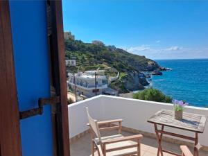 a balcony with a table and chairs and the ocean at Louis Studios and Apartments Melitsaha Beach in Kalymnos