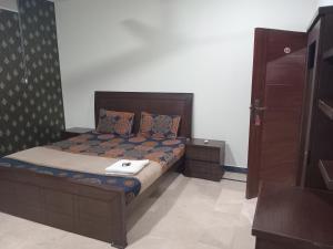 a bedroom with a bed with a wooden headboard at The Norvane G-13 in Islamabad