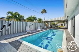 a swimming pool with chairs and a fence at Private Studio w Pool Patio steps to the Beach in Deerfield Beach