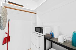 a small kitchen with a table with a microwave at Private Studio w Pool Patio steps to the Beach in Deerfield Beach