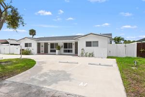 a white house with a fence at Private Studio w Pool Patio steps to the Beach in Deerfield Beach