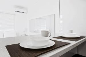 a kitchen counter with two bowls and plates on it at Private modern studio w pool - Steps to the beach in Deerfield Beach +9 photos