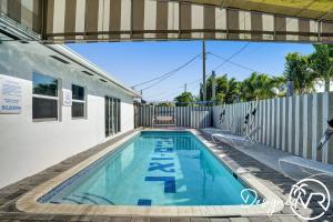 a swimming pool in the backyard of a house at Private modern studio w pool - Steps to the beach in Deerfield Beach